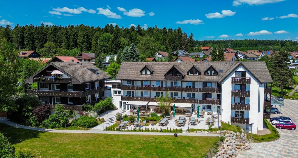 Luftbild des Wellnesshotels Hohenrodt mit dem Hotelgebäude und der angrenzenden Restaurantterrasse, eingebettet in die natürliche Umgebung des Schwarzwaldes