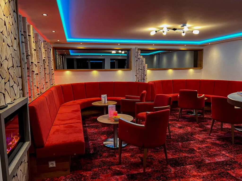 Wellnesshotel Hohenrodt, Rezeption und Lounge mit runden Sitzbänken für eine gemütliche und einladende Atmosphäre