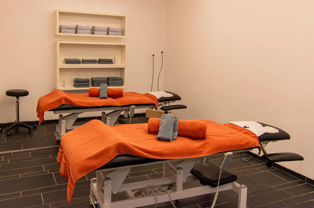Luxuriöser Massageraum für Partnermassagen mit Doppelbehandlungsliege und sanfter Beleuchtung im Wellnessbereich